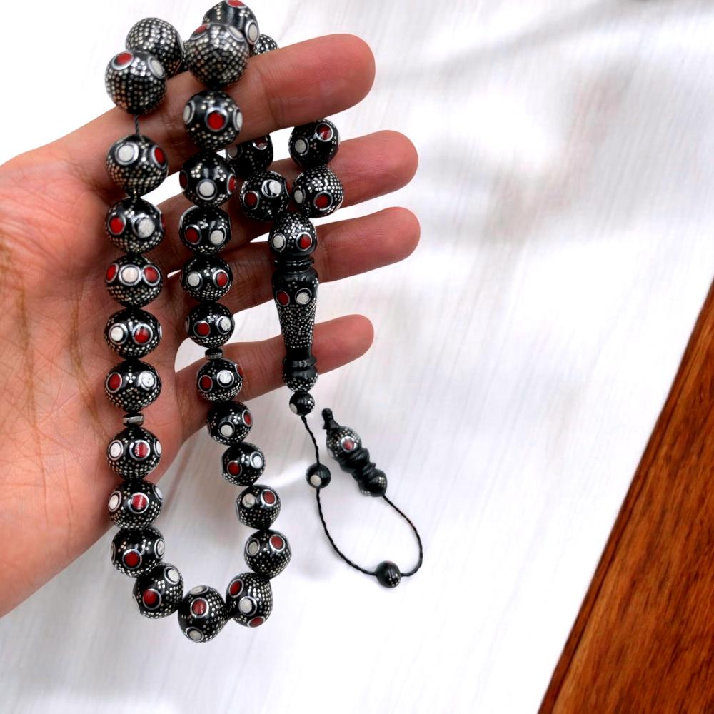 هذه مسبحة فضية مرصعة بالفيروز الأزرق والمرجان الأحمر.